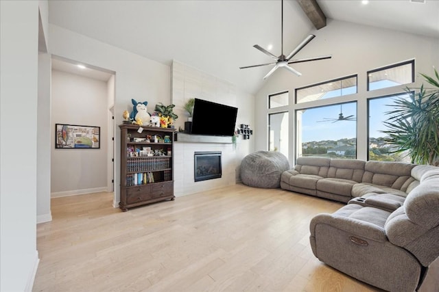 living room featuring beam ceiling, a fireplace, high vaulted ceiling, and light hardwood / wood-style flooring