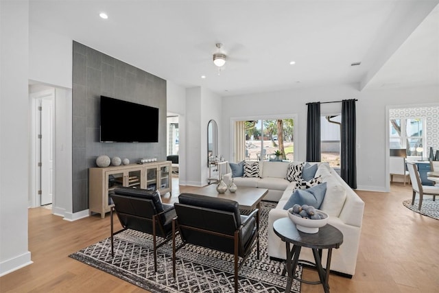 living room featuring ceiling fan and light hardwood / wood-style flooring