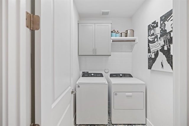 washroom featuring cabinets and independent washer and dryer