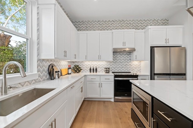 kitchen featuring a healthy amount of sunlight, white cabinetry, sink, and stainless steel appliances