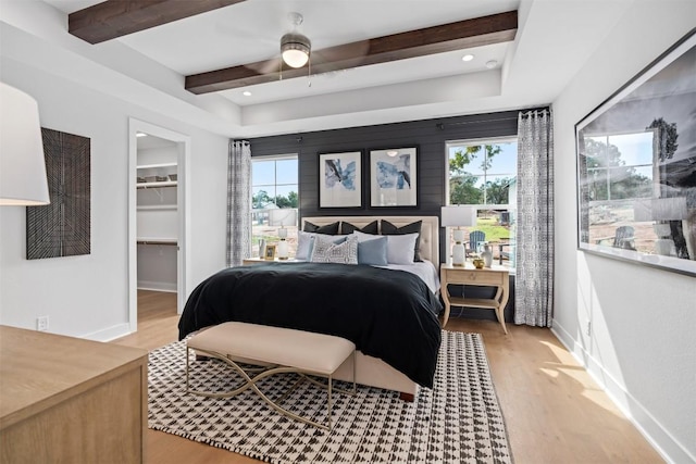 bedroom with multiple windows, a spacious closet, a closet, and ceiling fan