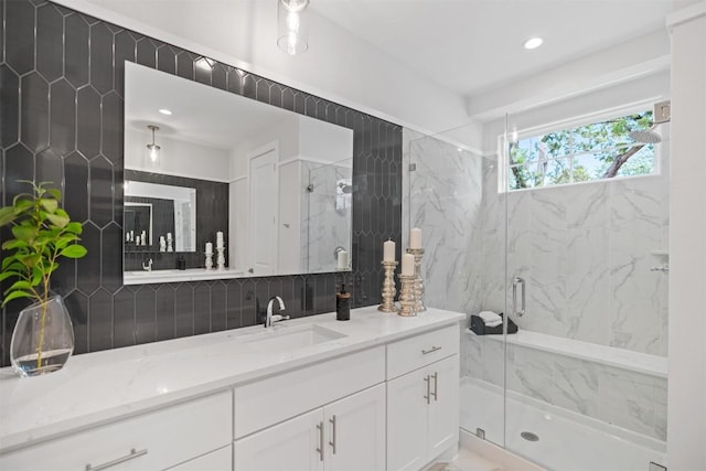 bathroom with backsplash, vanity, and a shower with shower door