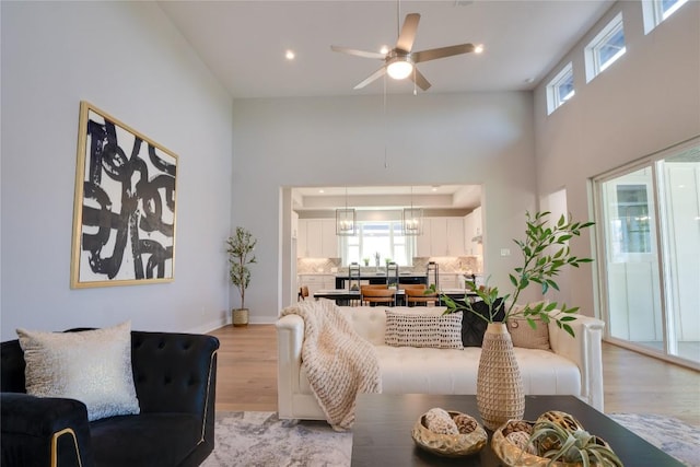 living room with light hardwood / wood-style flooring and ceiling fan