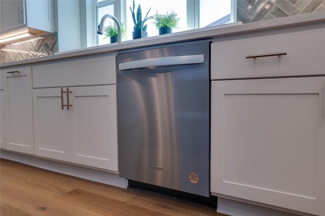 details with sink, white cabinets, stainless steel dishwasher, and light hardwood / wood-style flooring