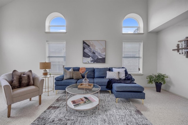 living room with carpet and a towering ceiling