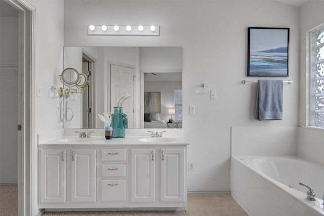 bathroom with tile patterned floors, vanity, and a washtub