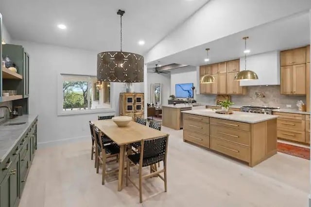 kitchen with hanging light fixtures, decorative backsplash, sink, and a kitchen island