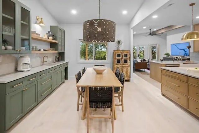 kitchen featuring hanging light fixtures, sink, decorative backsplash, and green cabinetry