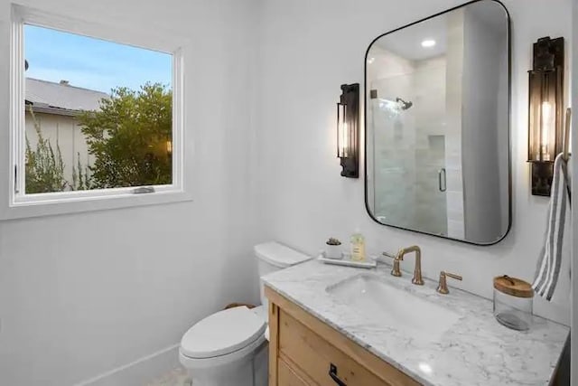 bathroom featuring vanity, toilet, and a shower with shower door