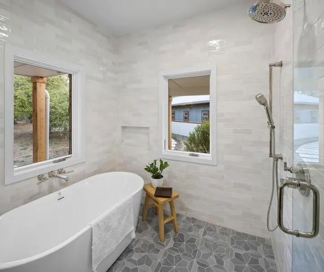 bathroom featuring shower with separate bathtub and a healthy amount of sunlight