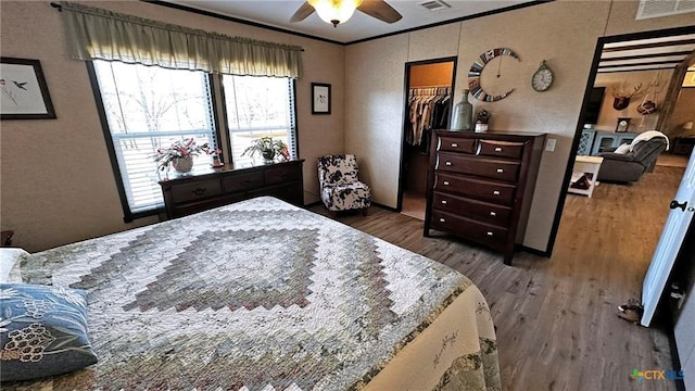 bedroom featuring ceiling fan, ornamental molding, dark hardwood / wood-style floors, and a closet