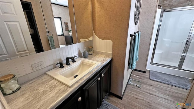 bathroom featuring vanity, a shower with door, and wood-type flooring