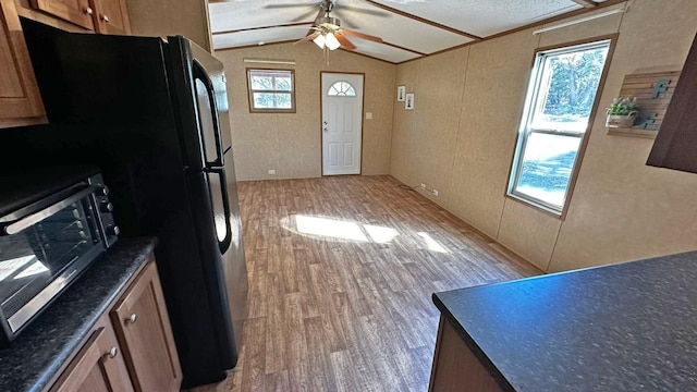 kitchen with ceiling fan, light hardwood / wood-style floors, and vaulted ceiling