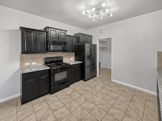 kitchen with decorative backsplash, light stone counters, black appliances, light tile patterned floors, and an inviting chandelier