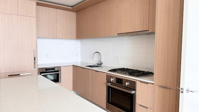 kitchen featuring appliances with stainless steel finishes, light brown cabinets, and sink