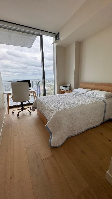 bedroom featuring floor to ceiling windows and hardwood / wood-style floors