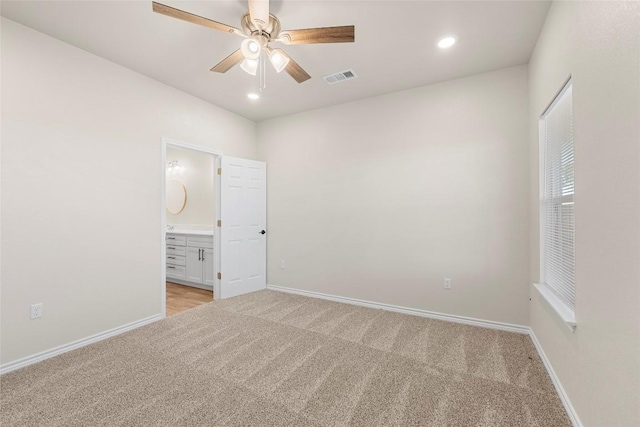 unfurnished bedroom featuring ensuite bathroom, ceiling fan, and light colored carpet