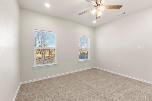 empty room with a wealth of natural light, carpet, and ceiling fan