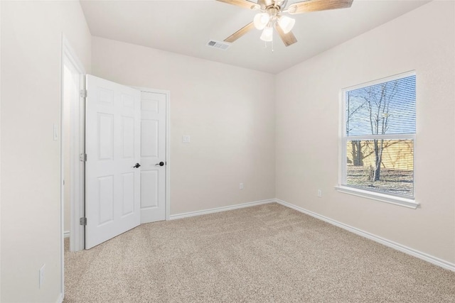 empty room featuring ceiling fan and light colored carpet