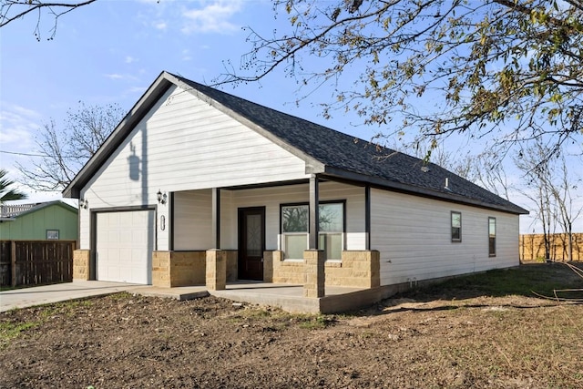 view of property exterior with covered porch and a garage