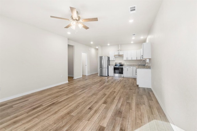 unfurnished living room with light hardwood / wood-style flooring, ceiling fan, and sink