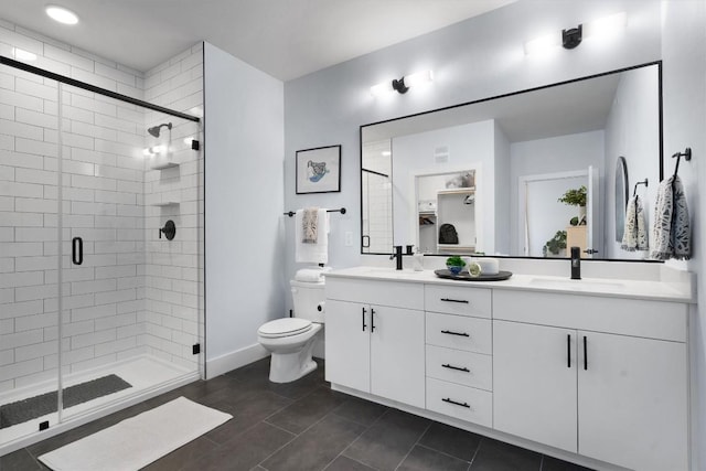 bathroom with tile patterned floors, a shower with door, vanity, and toilet