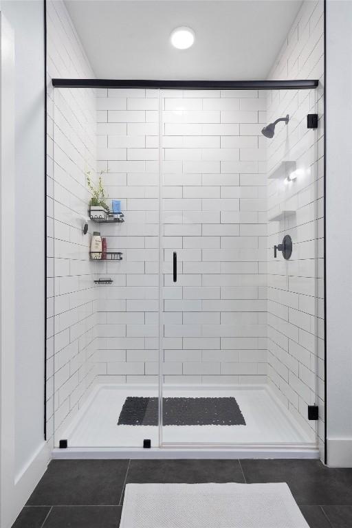 bathroom with tile patterned flooring and a shower with shower door