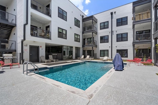 view of swimming pool featuring a patio area and a grill