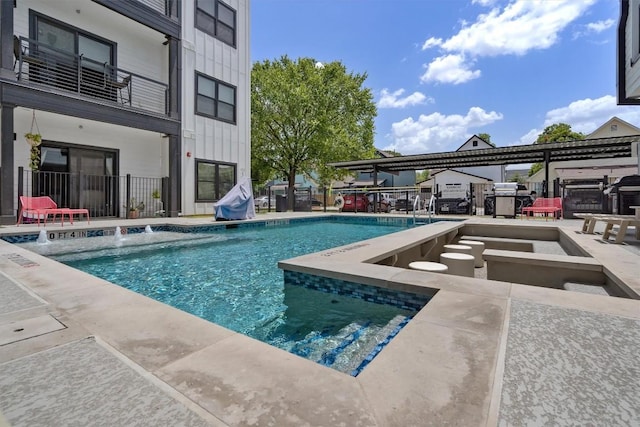 view of swimming pool featuring pool water feature, a grill, and a patio