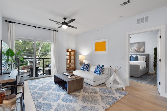 living room featuring light hardwood / wood-style floors and ceiling fan