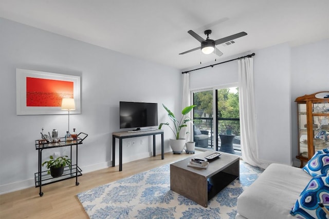 living room with light wood-type flooring and ceiling fan