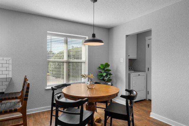 dining room with dark hardwood / wood-style flooring and washing machine and clothes dryer