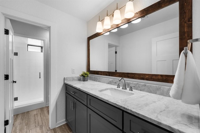 bathroom featuring a shower, hardwood / wood-style floors, and vanity