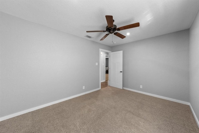 carpeted spare room with ceiling fan and a textured ceiling