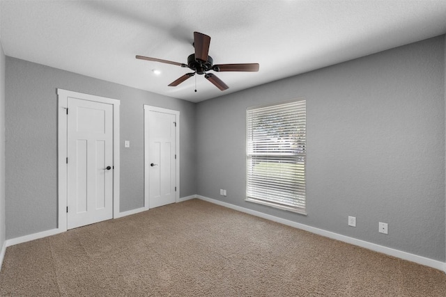 carpeted spare room featuring ceiling fan