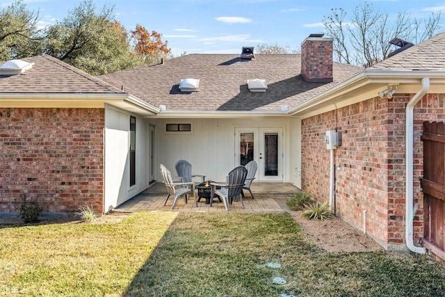 back of house featuring a lawn, a patio area, and french doors