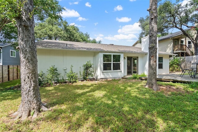 rear view of house featuring a deck and a yard