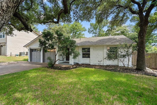 ranch-style home featuring a front lawn, a garage, and central AC