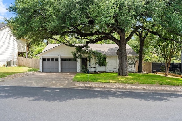 view of front of property featuring central air condition unit, a front yard, and a garage