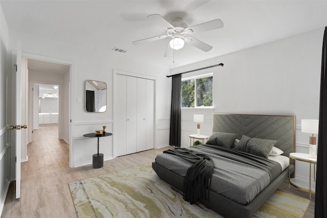 bedroom with ceiling fan, light hardwood / wood-style floors, and a closet