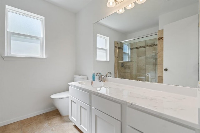 bathroom with vanity, a healthy amount of sunlight, toilet, and a shower with shower door