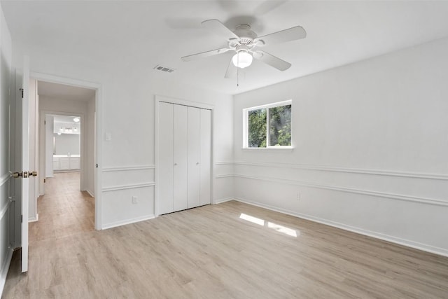 unfurnished bedroom featuring a closet, light hardwood / wood-style flooring, and ceiling fan