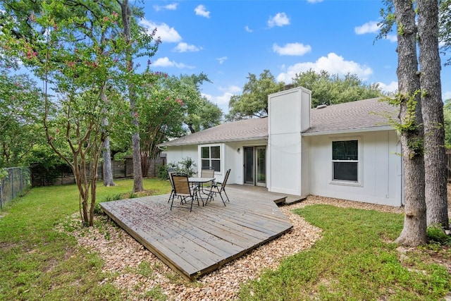 back of house with a deck and a yard