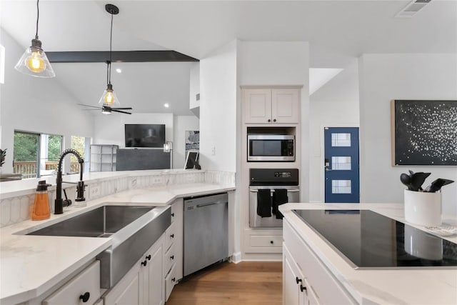 210 Finn St, Austin, TX 78734 - kitchen with appliances with stainless steel finishes, a sink, light wood-style floors, decorative light fixtures, and light stone counters