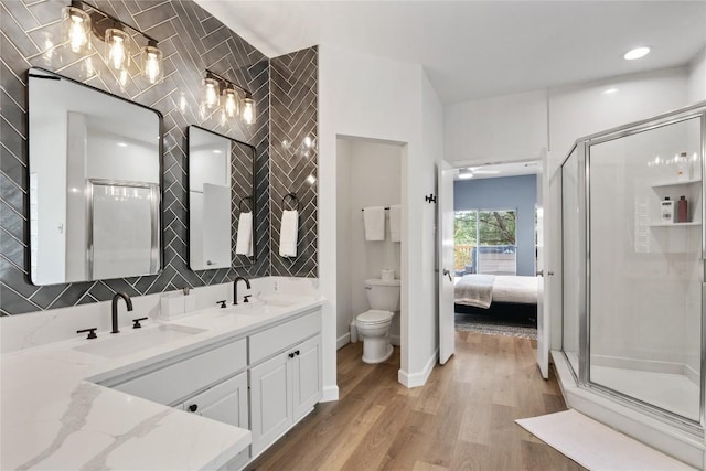 210 Finn St, Austin, TX 78734 - full bath featuring toilet, double vanity, wood finished floors, a shower stall, and tasteful backsplash
