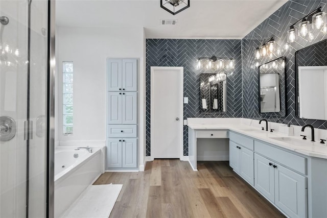 210 Finn St, Austin, TX 78734 - bathroom with a jetted tub, double vanity, a shower stall, wood finished floors, and decorative backsplash