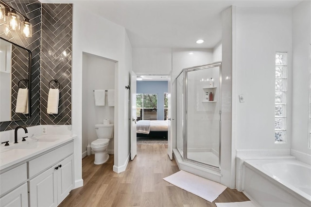 full bathroom featuring hardwood / wood-style flooring, vanity, toilet, and plus walk in shower