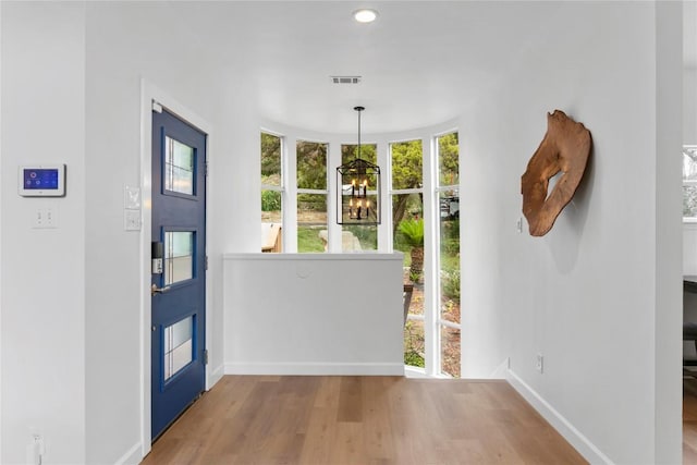 foyer entrance featuring hardwood / wood-style floors and a chandelier