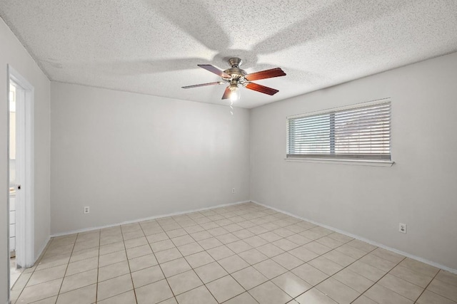 tiled empty room with ceiling fan and a textured ceiling