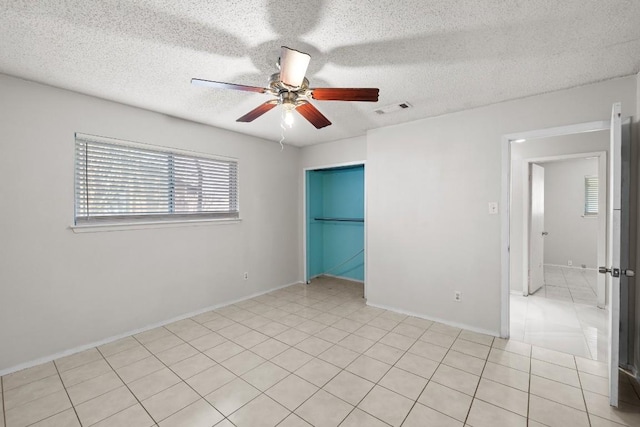 tiled empty room with a textured ceiling and ceiling fan